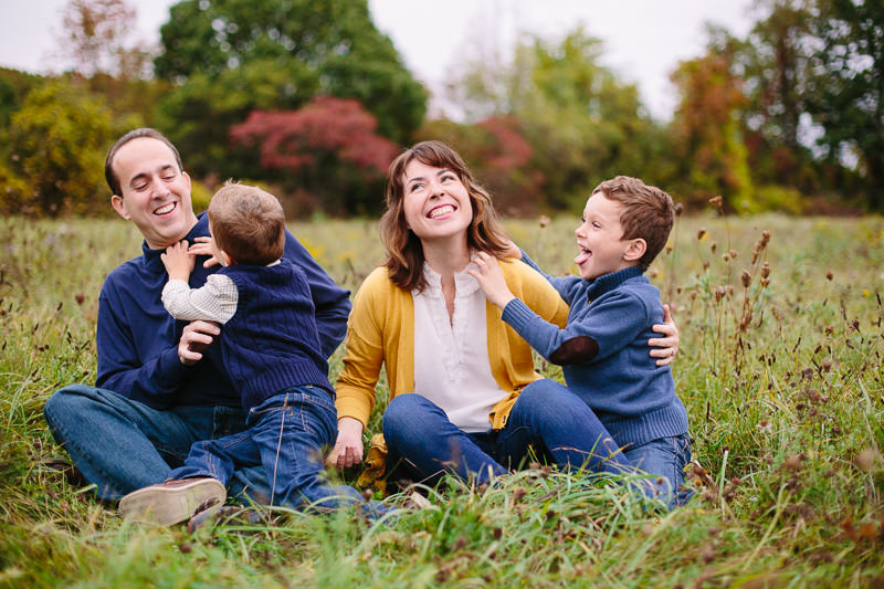 family sitting outside tickling and laughing