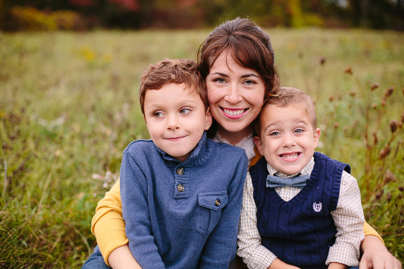 mom holding her two boys with blue shirts