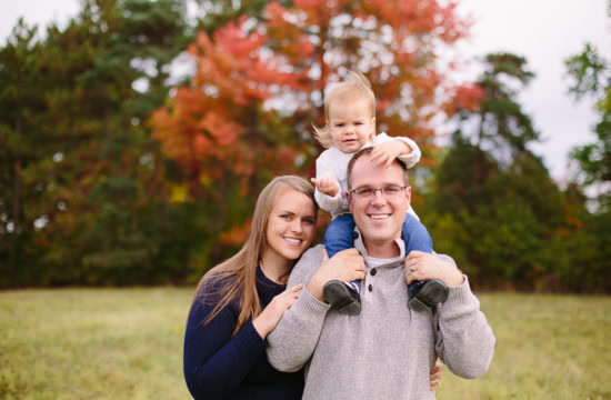 baby girl on shoulders of dad during family picture