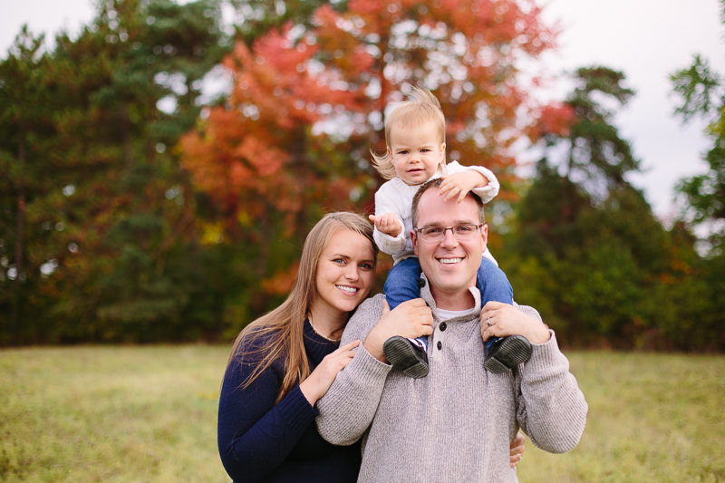 baby girl on shoulders of dad during family picture