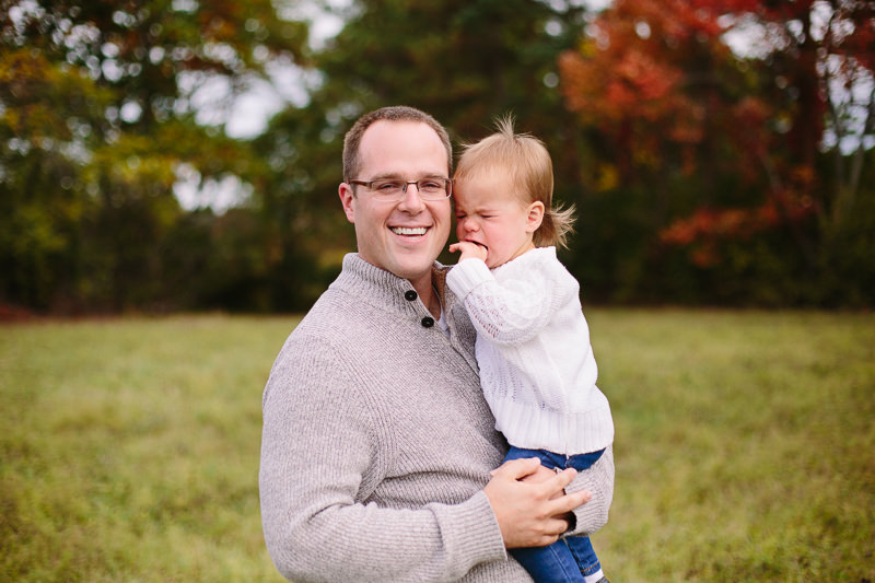 dad holding sad baby girl
