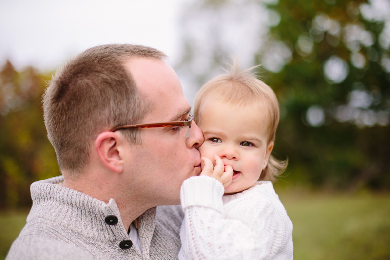 close up of dad kissing baby daughter on the cheek