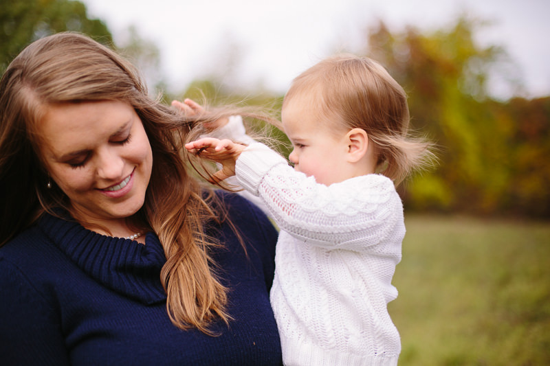 baby girl playing with moms hair