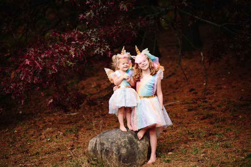 Two girls wearing unicorn Halloween costumes