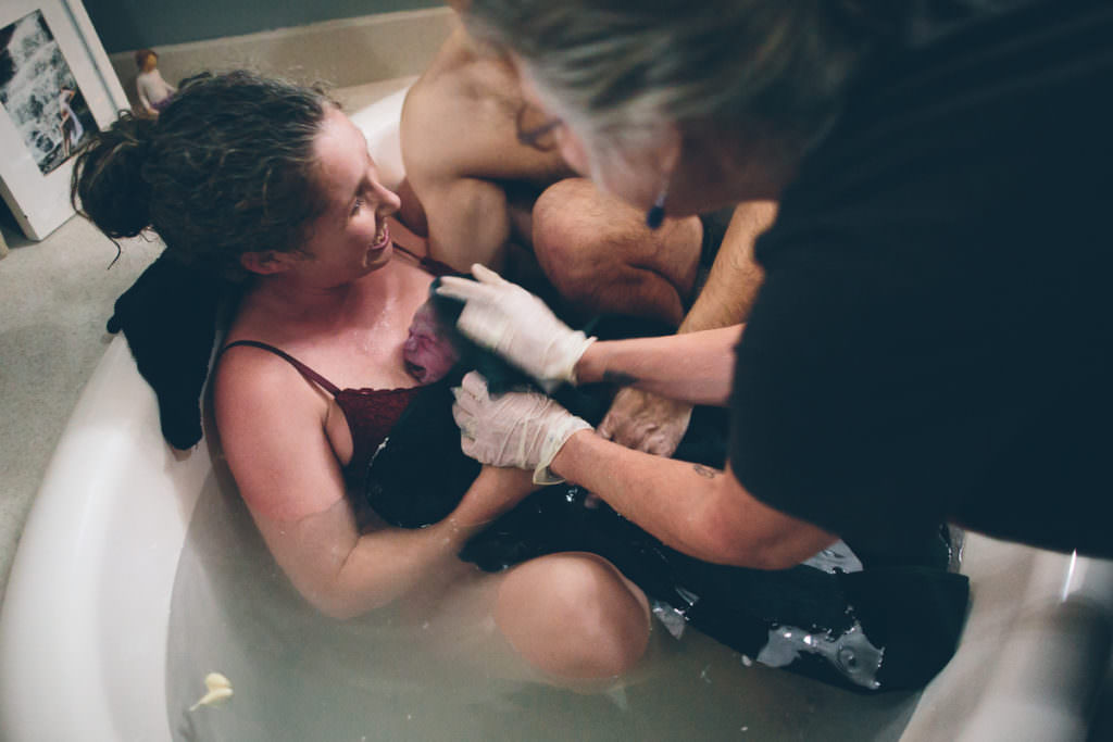 mom in tub happy after water birth