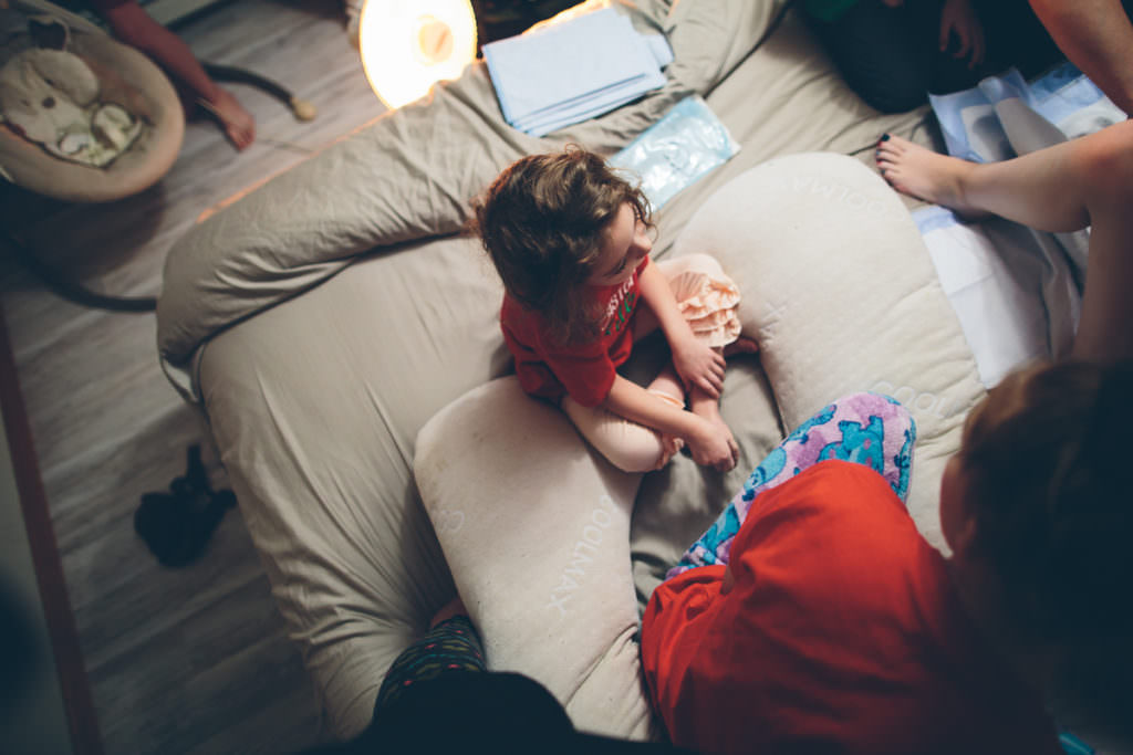 little sister on bed after homebirth
