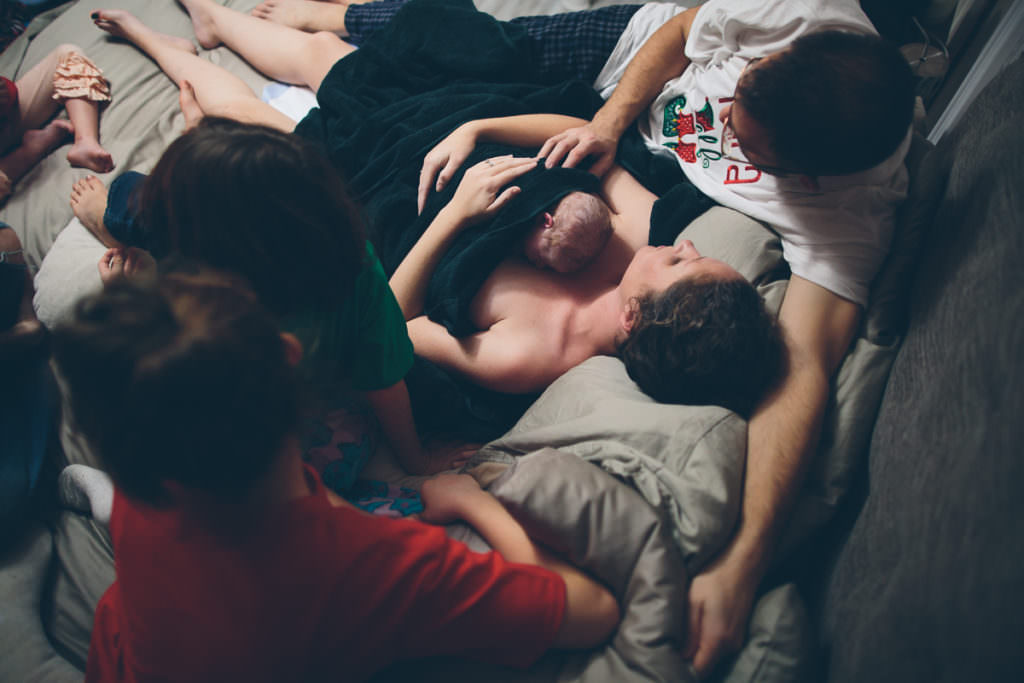 family gathered to see new baby right after birth