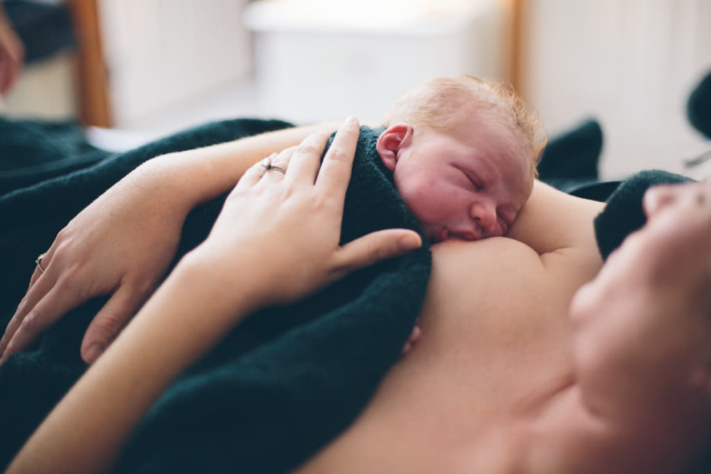 newborn baby boy nursing after home birth