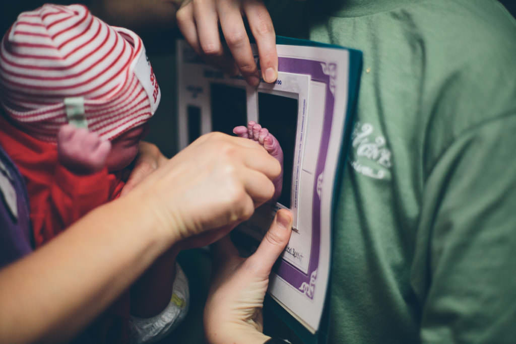newborn baby getting footprints