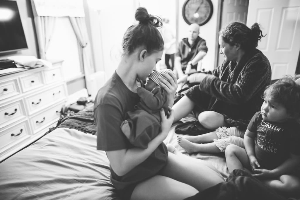 oldest sister holding new baby brother