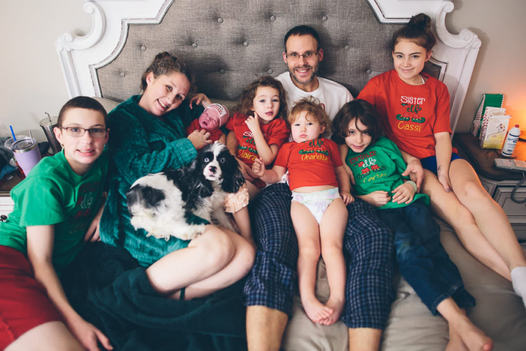 new family of 8 on bed after homebirth