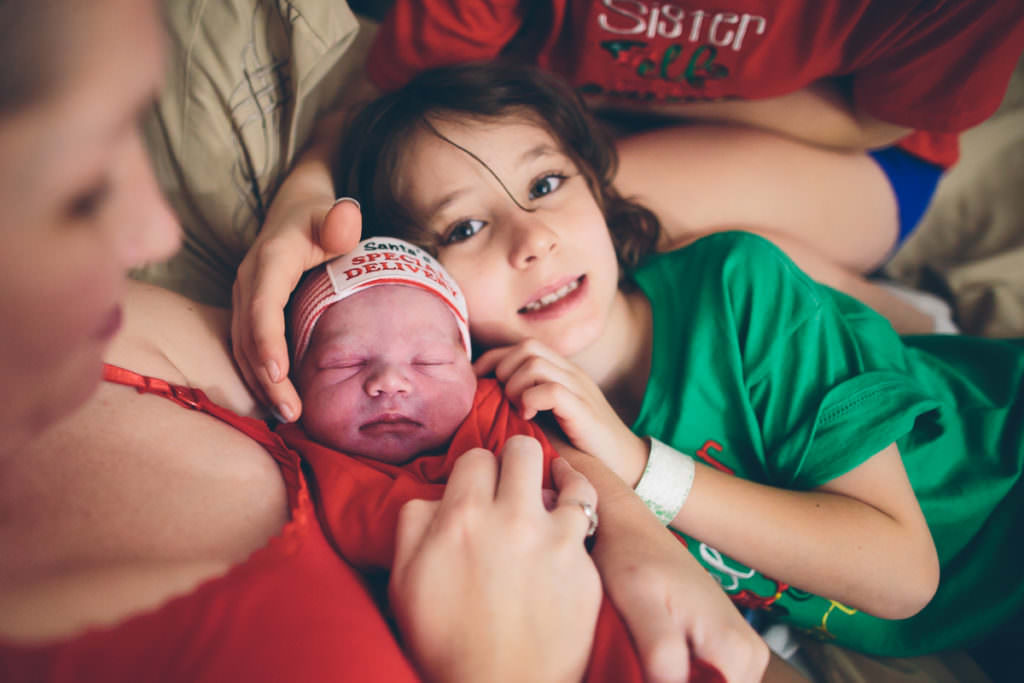 snuggling new baby brother after home birth