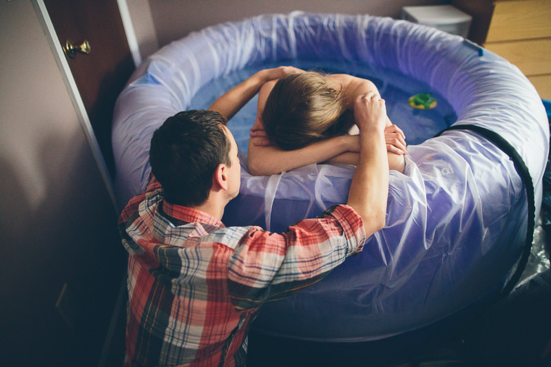 husband helping laboring wife waterbirth
