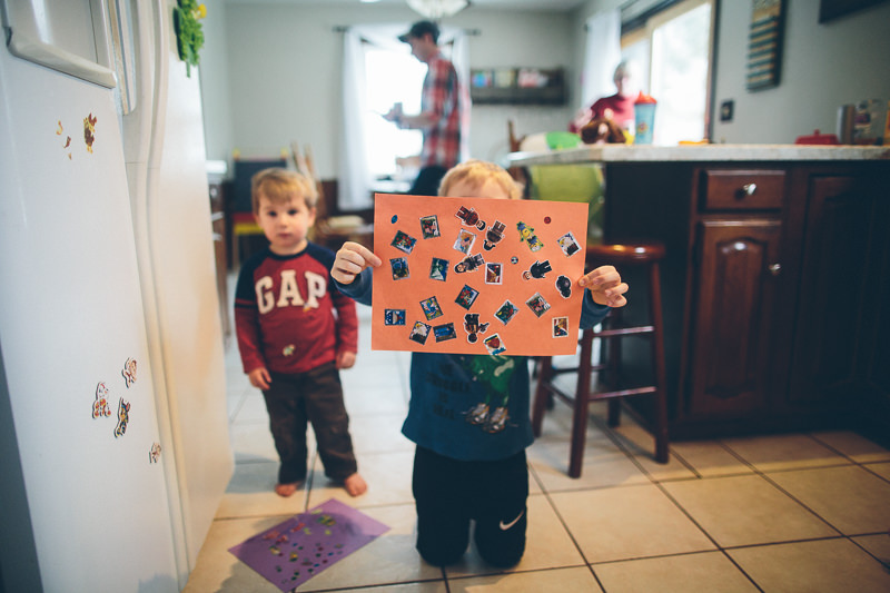 two boys holding paper with stickers