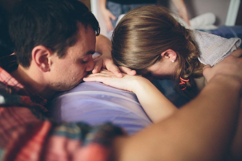 close up husband supporting laboring mom