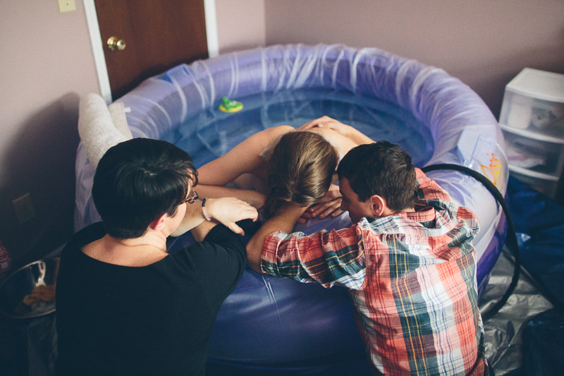 doula and husband helping waterbirth