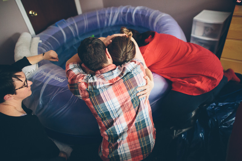 holding husband tight while pushing baby out