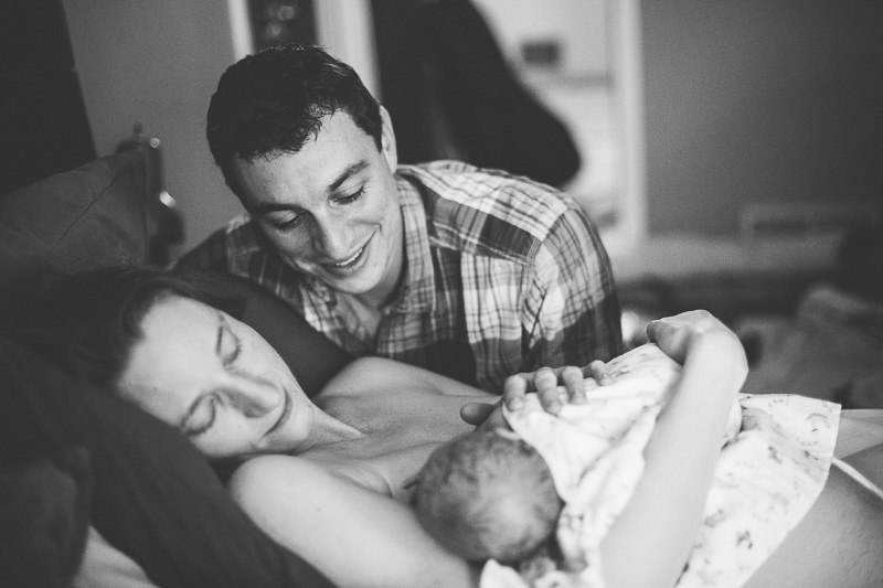 mom and dad looking at new baby