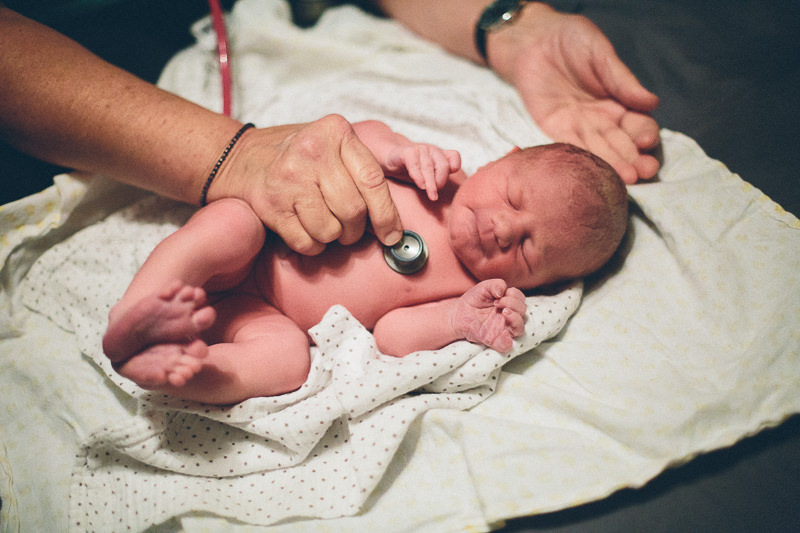newborn exam midwife listening to heart