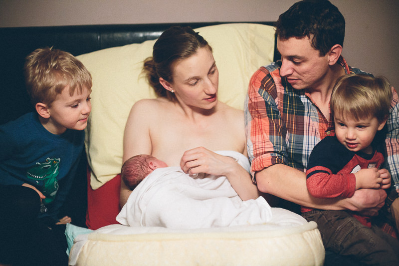 family of five talking to new baby