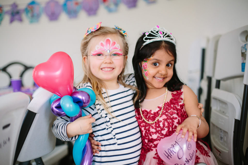 little girls wearing crowns and holding balloon wands 
