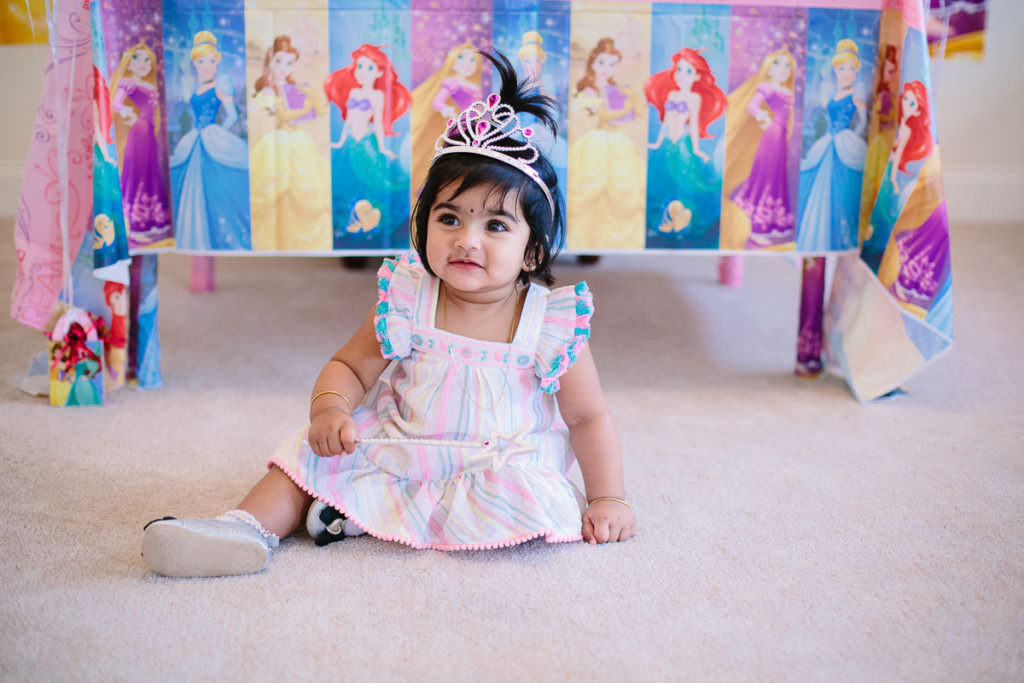 baby girl with dark hair wearing a crown