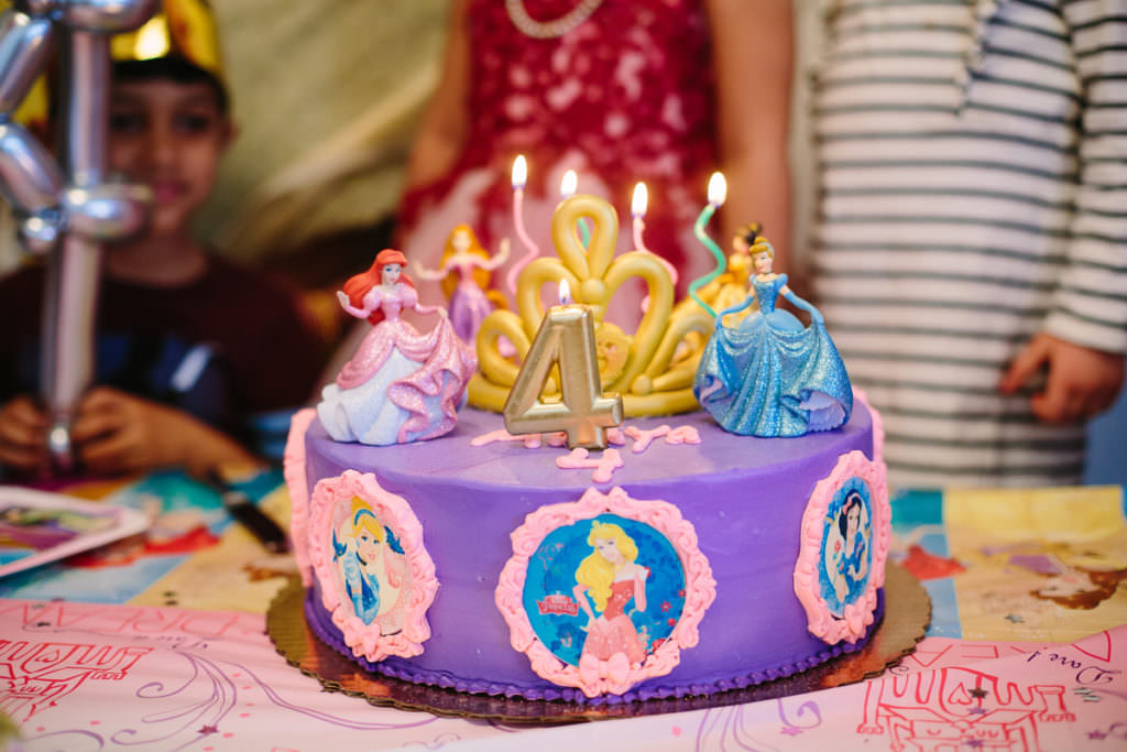 purple princess cake with candles lit