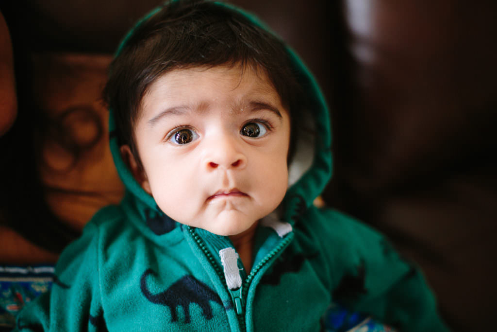 baby boy with dark hair green shirt