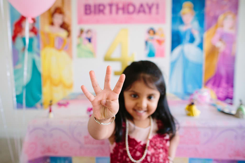 dark haired girl holding up 4 four fingers