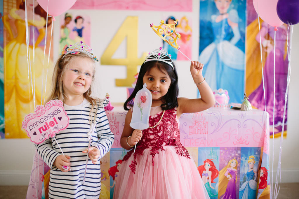 two little girls wearing crown and holding wand
