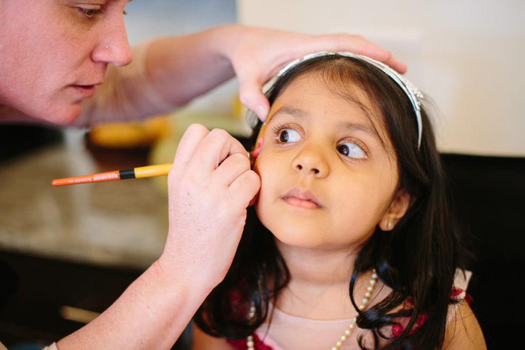 dark haired little girl getting face painted