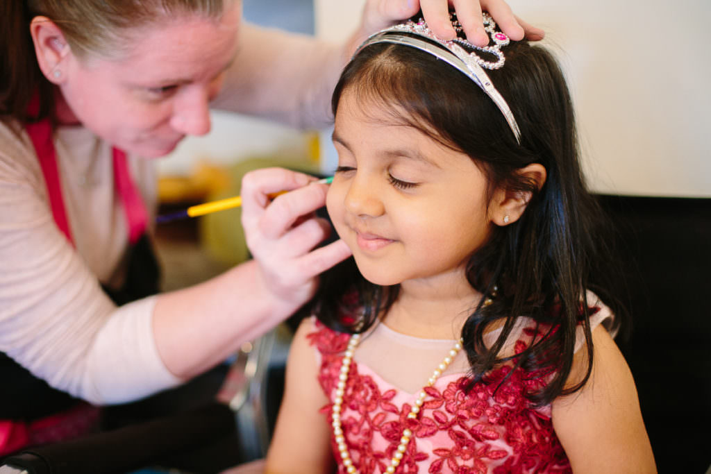 little girl eyes closed getting face painted