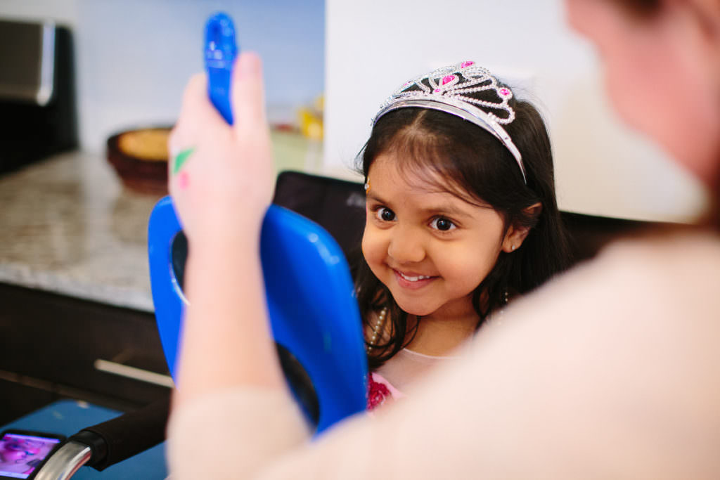 little girl looking in mirror after face painted