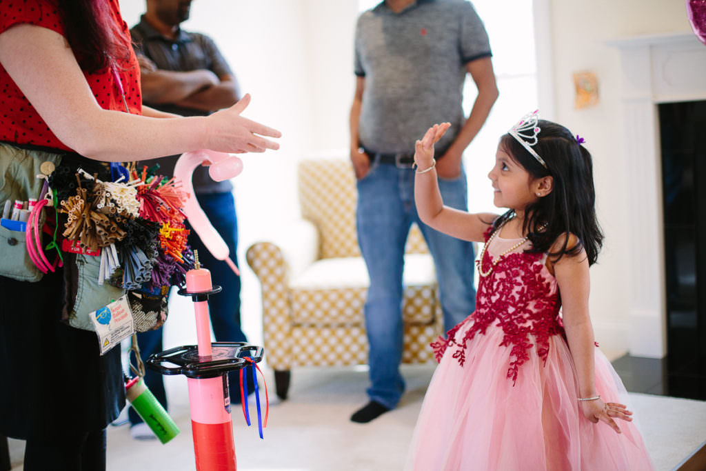 little girl showing she is four to balloon gal