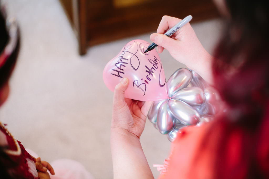 balloon gal writing happy birthday on balloon wand