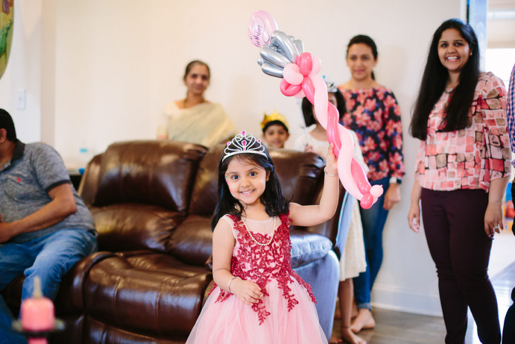 birthday girl holding up her balloon wand
