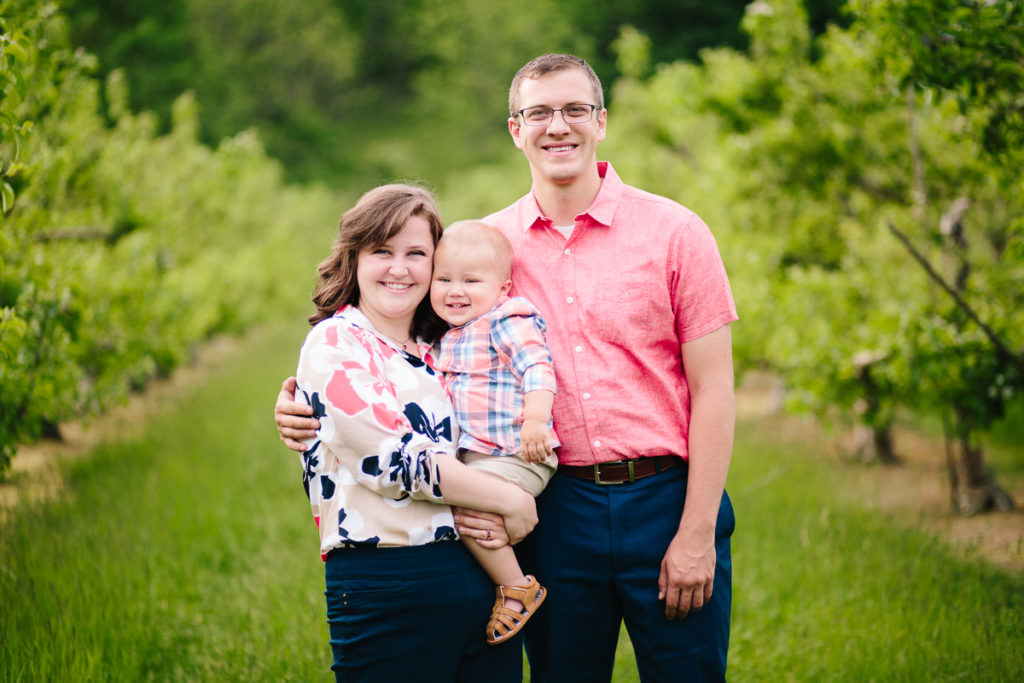 mom holding baby boy by dad in pink shirt
