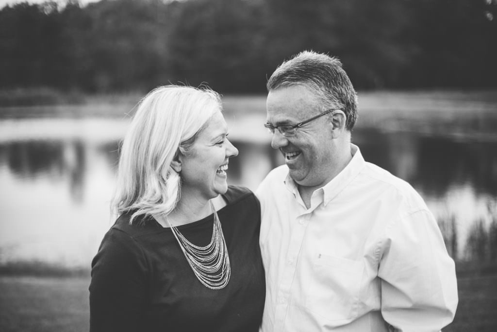 parents laughing at eachother by pond
