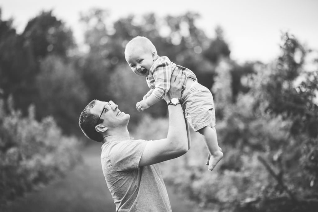dad holding up baby boy in airplane