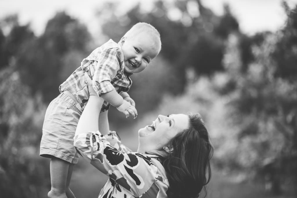 mom holding baby in apple orchard