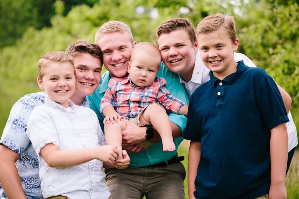 five uncles holding baby nephew