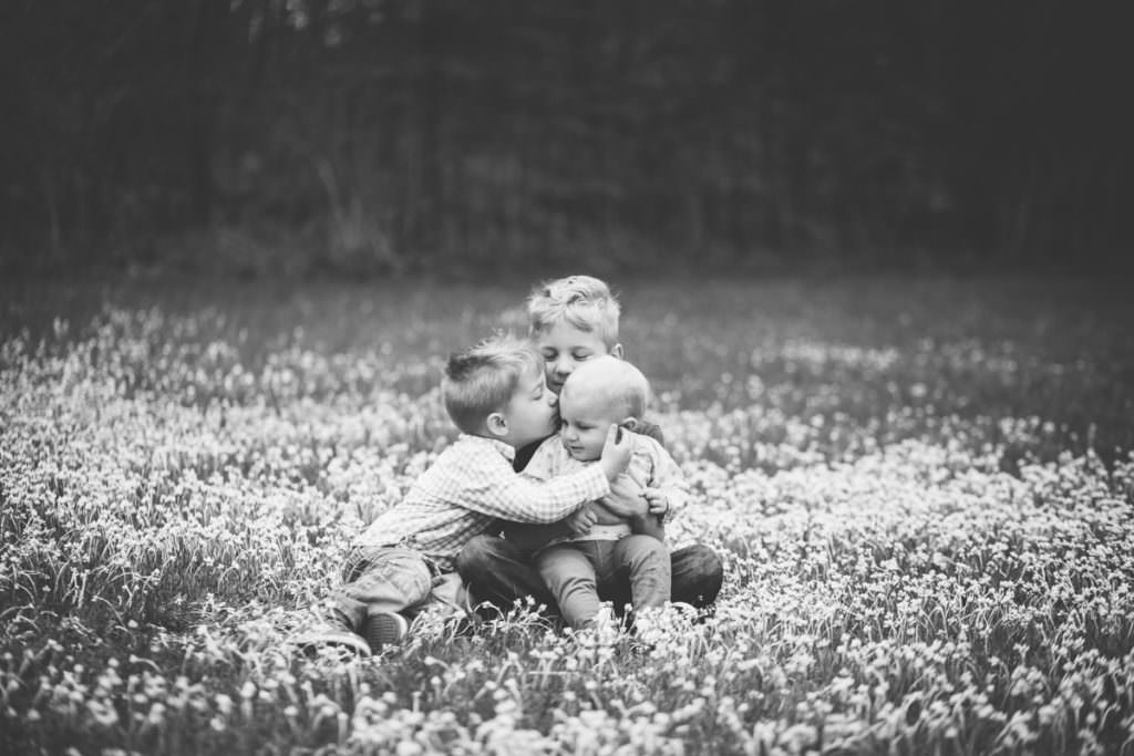 big brothers kissing baby sister