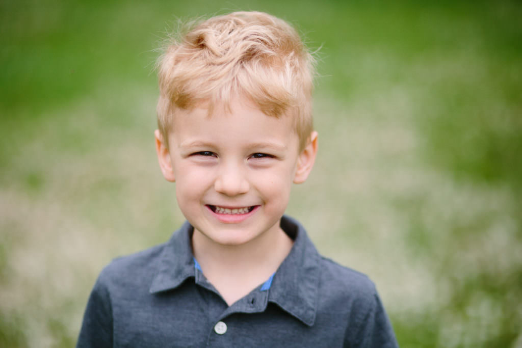blond hair little boy standing in field