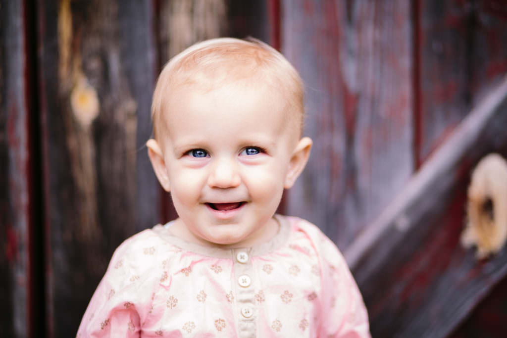 baby girl wearing pink shirt blue eyes