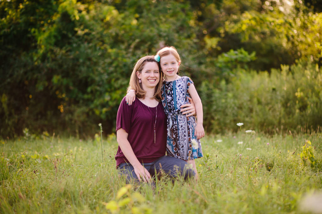 mom kneeling and daughter hugging mom