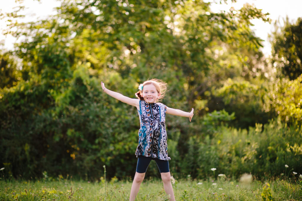 girl jumping in a field at garnsey park