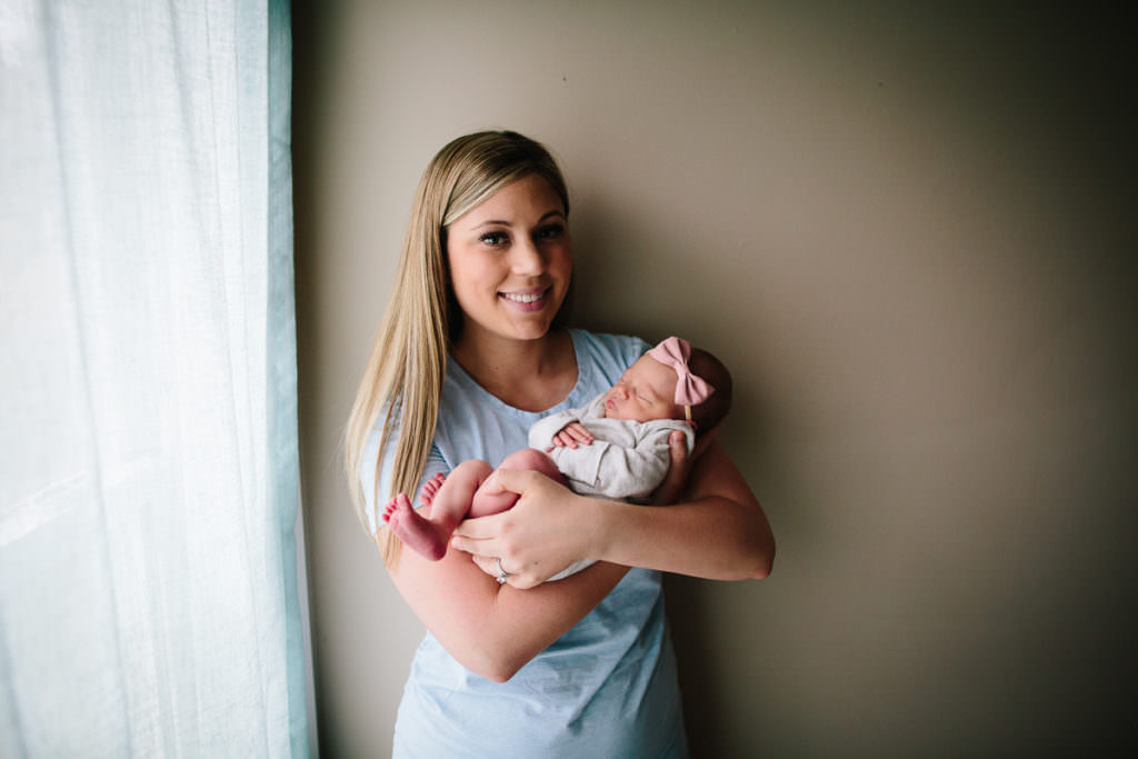 mom in blue shirt holing baby