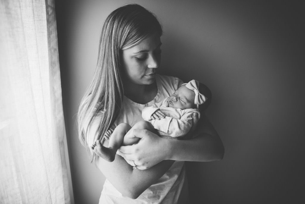 black and white picture of mom looking at newborn