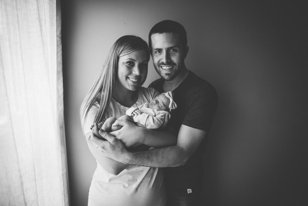 black and white mom dad and baby photograph