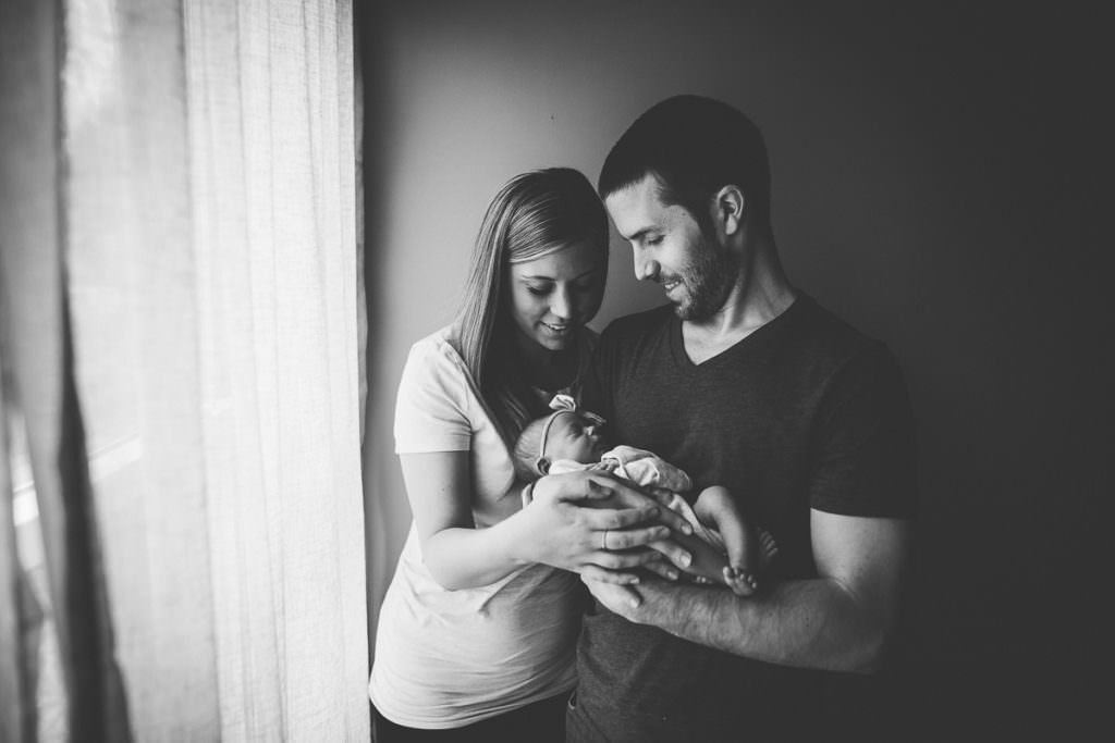 mom and dad looking at newborn baby girl